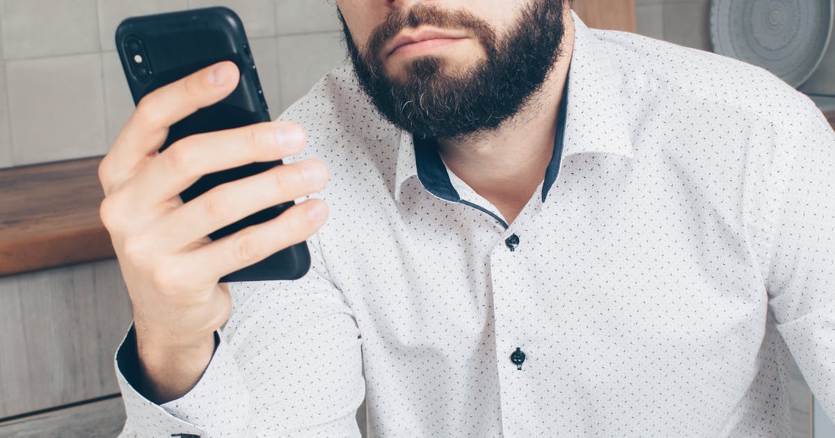 スマートフォンの画面を凝視してエラーを確認している様子